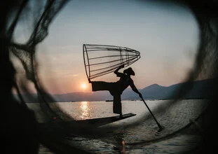 Fotokunst eines burmesischen Fischers auf einem ruhigen See bei Sonnenuntergang.