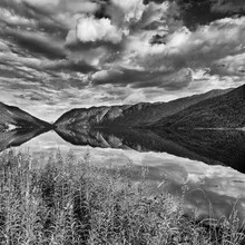 Beautiful lake with mountains and clouds in Norway, calm and peaceful atmosphere.