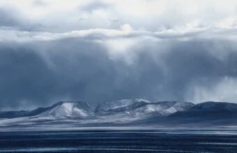 Photo art by Victoria Knobloch: serene mountain lake with dramatic clouds in Kyrgyzstan