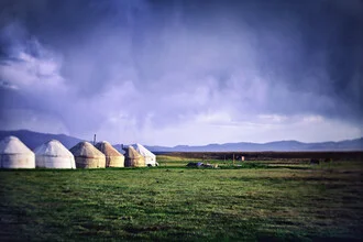 Photo art by Victoria Knobloch: yurts under a thunderstorm sky in Kyrgyzstan
