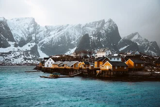 Fotografie von Lofoten: farbenfrohe Häuser am ruhigen Meer mit Bergen im Hintergrund