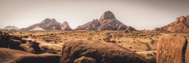 Panoramic view of Spitzkoppe in Namibia, gentle hills under a clear sky.