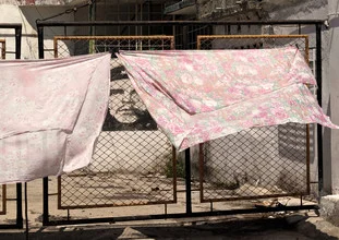 Photo art by Aurica Voss: Laundry hanging on a grid fence in a Cienfuegos backyard