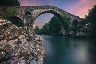 Photo of Canga de Onis: Roman bridge at sunset over the calm river.