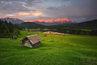 Photo art by Rolf Schnepp: gentle alpenglow over mountains and wooden cabins