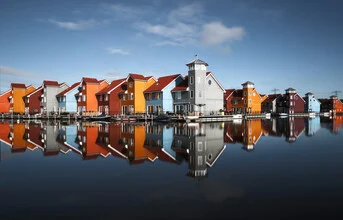 Colorful cityscape with vibrant houses reflected in calm water