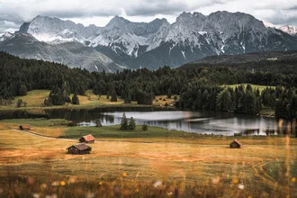 Photo of a tranquil Bavarian lake with gentle waves and surrounding mountains.
