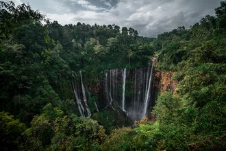 Beautiful waterfall in Indonesia, surrounded by lush jungle.
