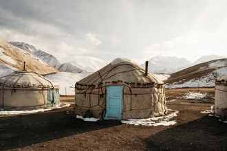Traditional yurt in the Pamir Mountains, serene landscape with mountains in the background.