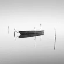 Calm boat on Hohennauener Lake, surrounded by misty landscape.