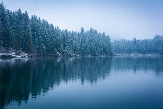 Winter landscape with a snowy lake and mountains in the background