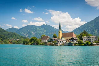 Summer scene at Tegernsee with mountains in the background and calm water.