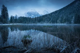 Winter landscape with snow-covered mountains and a serene lake in Berchtesgaden