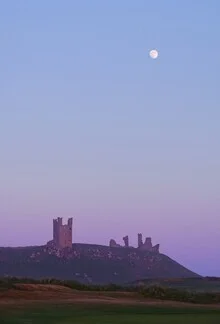 Photo art by Alex Wesche: Moon over Dunstanburgh Castle during blue hour
