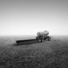 Agricultural vehicle in fog, surrounded by autumn scenery.