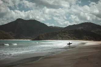 Wall art of a surfer on a tranquil, lonely beach in Indonesia