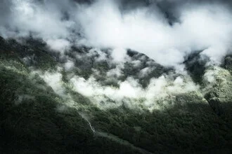 Cloud front over mountains in Norway, gentle sun rays break through the clouds.