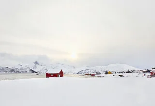 Morning mood in Skulsfjord featuring colorful houses and snow-capped mountains.