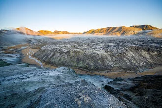 View over a lava field in Landmannalaugar, Iceland, with blue sky and clouds.
