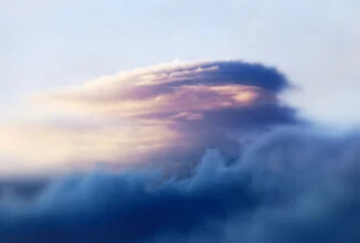 Fluffy clouds over a serene landscape in Norway.
