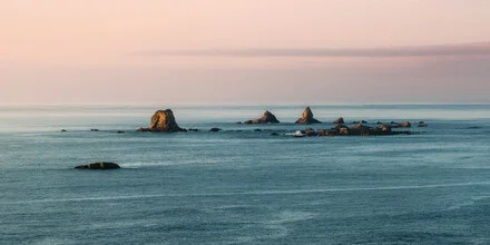 Photo art: calm sunset over the ocean with gentle waves and rocks