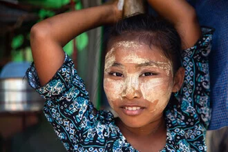 Smiling girl from Myanmar with Tanaka, friendly and mysterious.