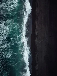 Photo of black sand beach in Kamchatka with calm ocean in the background