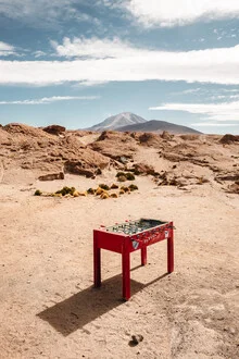 Photo of a foosball table in the desert, surrounded by a vast landscape view.