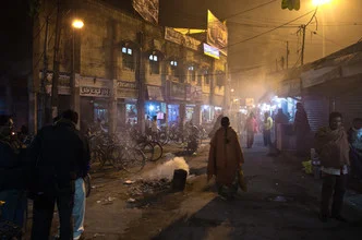 Nachtaufnahme der Hauptstraße in Balurghat, Indien, in nebliger Atmosphäre.