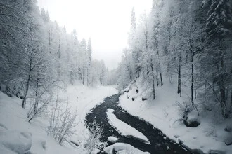 Winterlandschaft mit schneebedecktem Fluss und Bäumen in Bayern