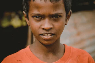 Portrait of a strong boy with a striking gaze in a Sri Lankan slum.
