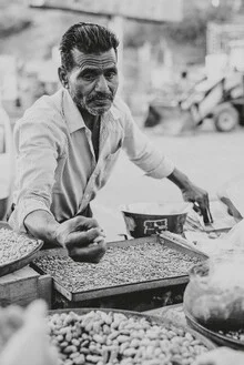 Portrait of a nut vendor in an Indian market, friendly and approachable.