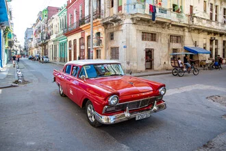 Fotokunst von Miro May: Rotes Auto an einer belebten Kreuzung in Havanna.