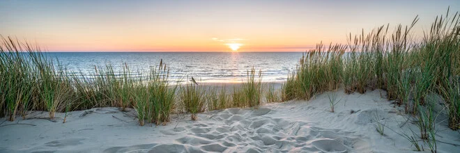 Sunset at the dunes beach with gentle waves and warm colors