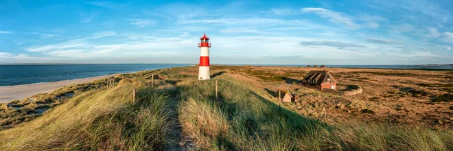 Lichtdurchfluteter Leuchtturm auf Sylt mit Meer und Dünen in sanften Farben