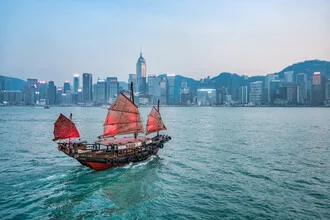 Photo of a Chinese junk in Hong Kong harbor with skyscrapers in the background