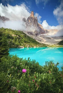 Beautiful mountain lake in summer, surrounded by lush forests and majestic mountains.