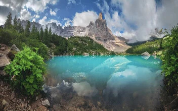 Panoramic view of Lago di Sorapis in Italy with calm water surface and mountains