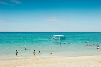 Colorful photo art of Jamaica: children and adults playing on the beach in the sun.
