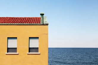 Photo art by Rupert Höller: minimalist depiction of a yellow house by the sea