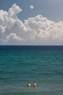 Photo art by AJ Schokora: two swimmers in water beneath a moody sky