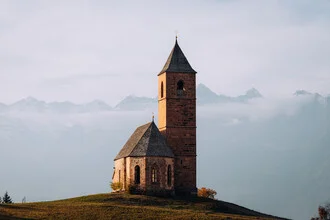 Fotokunst von André Alexander: St. Kathrein Kirche in den Dolomiten unter wolkenverhangenem Himmel