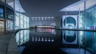 Night photo of Berlin's government district with reflecting buildings.