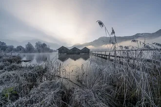 Three cabins at Lake Kochel, surrounded by soft fog, calm water surface.