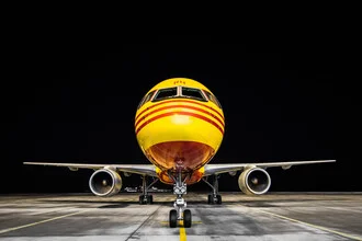 Photo art by Inflight Galerie: yellow airplane at the airport at night