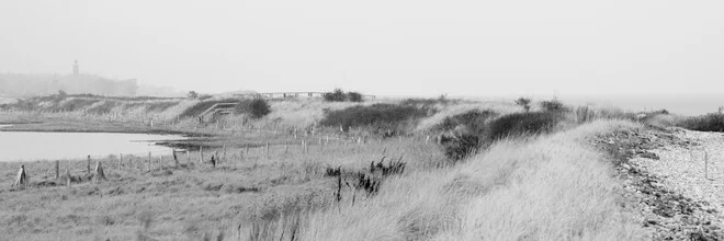 Calm landscape featuring a dike, water, and fog along the Baltic Sea shore