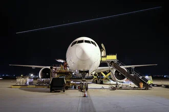 Fotokunst von Inflight Galerie: Frontansicht einer Boeing 777F im klaren Himmel