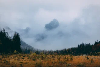 Mystisches Tal mit Bergen und Nebel, ruhige Stimmung in sanften Grautönen.
