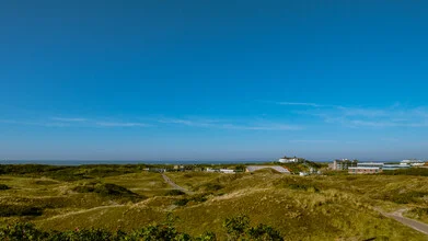 Photo art of a dune landscape on Langeoog with gentle sand hills under a cloudy sky.