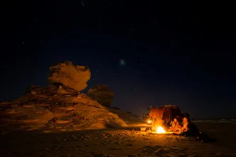 Photo art by Mono Elemento: people and fire under a clear starry sky in the desert